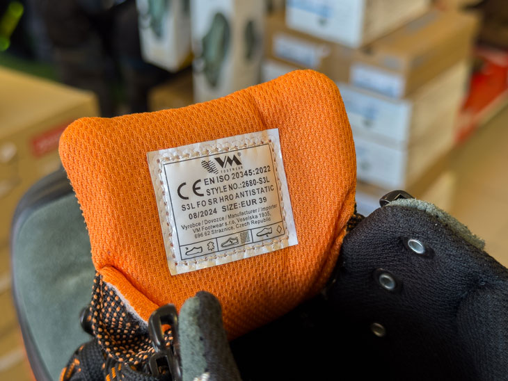 Munkavédelmi bakancs nyelvének belső oldalán lévő címke a lábbeli tulajdonságaival